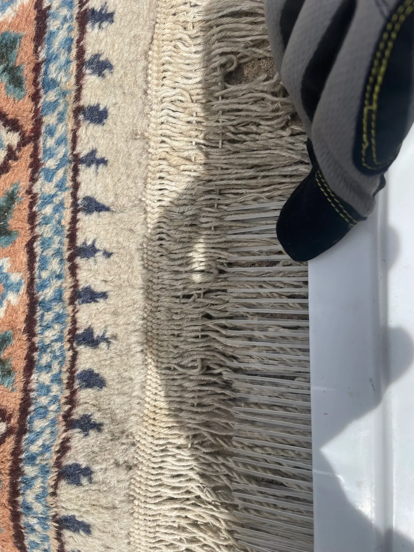 Dallas rug cleaning—technician grooming Haitian cotton fringe for even drying